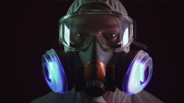 Man in protective costume suit, gas protect medical antibacterial antiviral spray paint mask. Doctor health worker in respirator. Concept health virus coronavirus epidemic. Radiation Nuclear war.