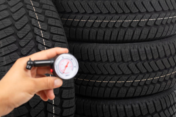 Close up picture of black new car tyre and mechanic's hand next to