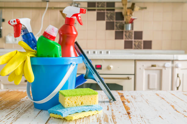 Cleaning concept - cleaning supplies, gloves, bottles on wood background, copy space, kitchen background