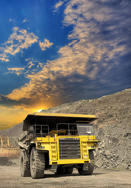 Heavy dump truck transporting iron ore from the opencast on sunset