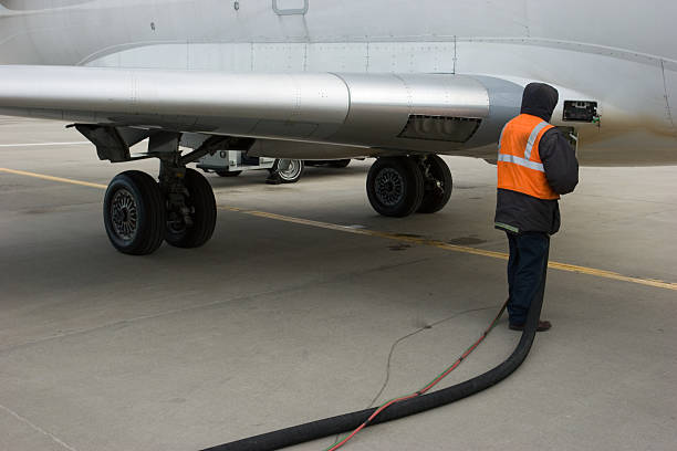 An airline employee refuels a jet