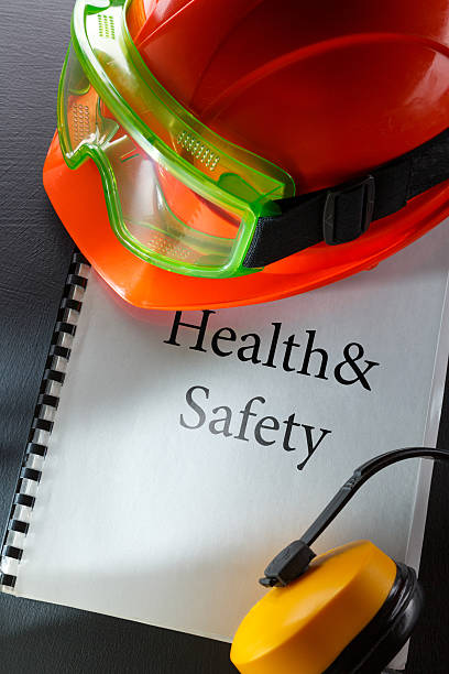 Safety goggles, earphones and red helmet