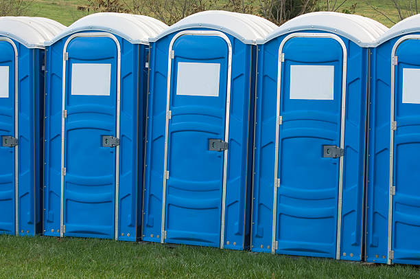 A row of blue portable toilets for crowd relief at an outdoor event.
